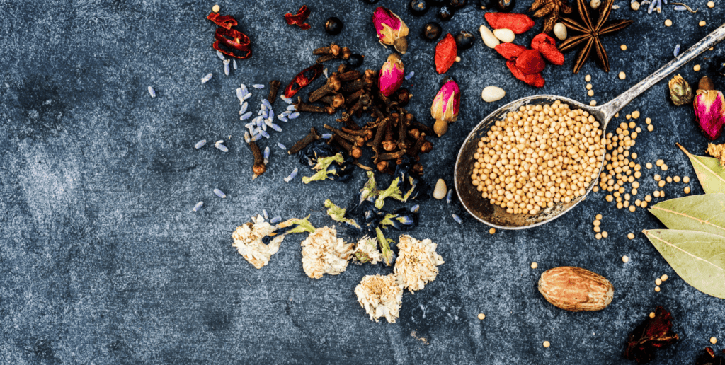 Aromatische Gewürze, Blüten und Senfkörner auf dunklem Hintergrund für natürliche Lebensmittel und Gewürzmischungen