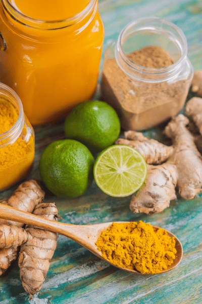 Kurkuma, Ingwer und Limetten mit Gewürzpulver und Getränk für natürliche Zutaten und Wellness