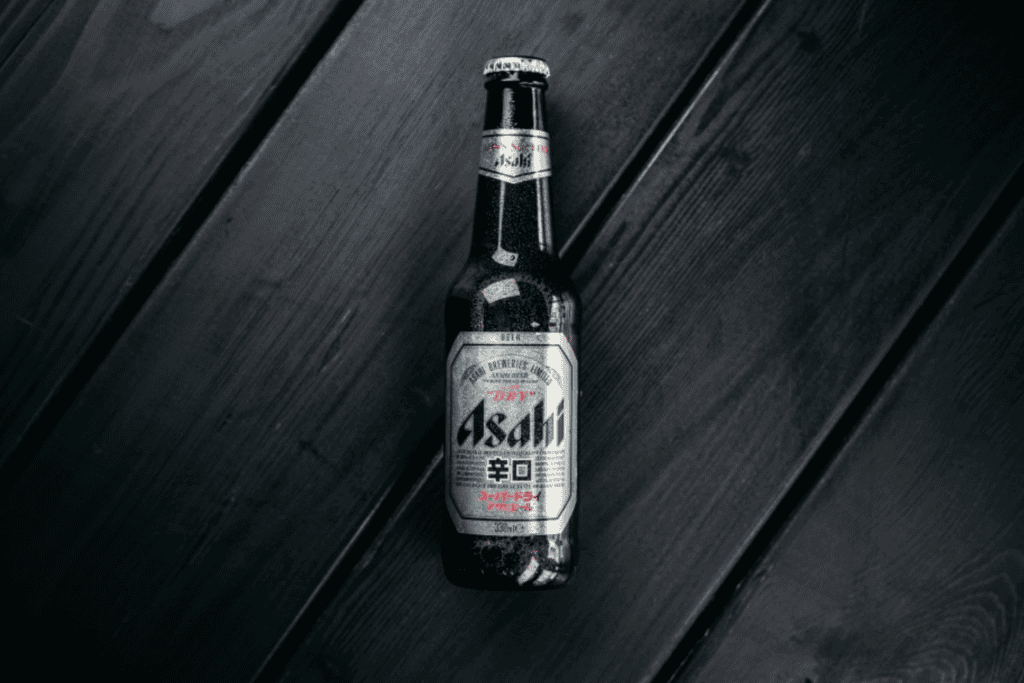 Asahi Super Dry Bierflasche auf dunkler Holzoberfläche