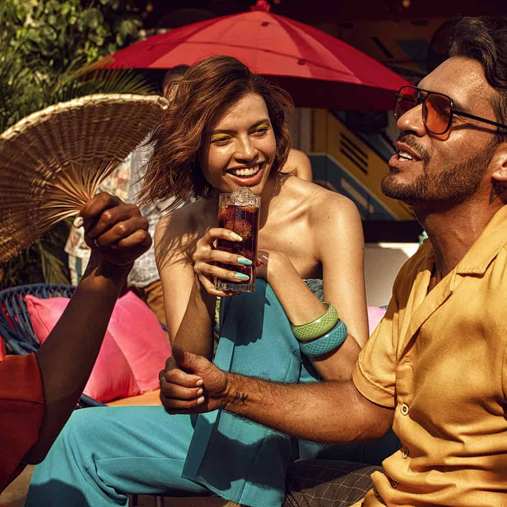 Freunde genießen Bacardi Rum-Cola bei sommerlicher Outdoor-Party