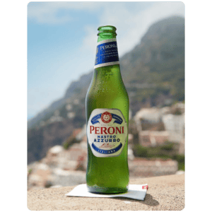 Peroni Nastro Azzurro Bierflasche vor italienischer Küstenlandschaft