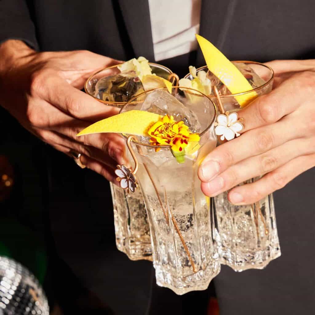 Drei Gläser St. Germain Spritz die von zwei Händen gehalten werden