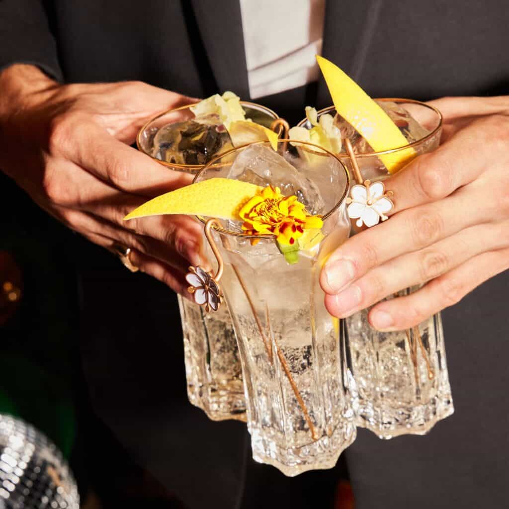 Drei Gläser St. Germain Spritz die von zwei Händen gehalten werden