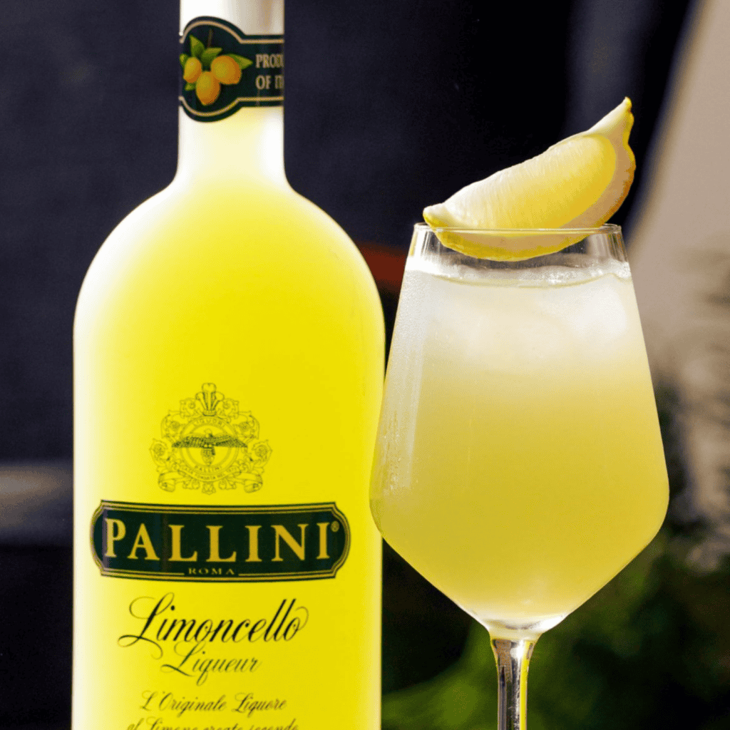 Pallini Limoncello mit Zitronenlikör im Glas und Zitronenspalte