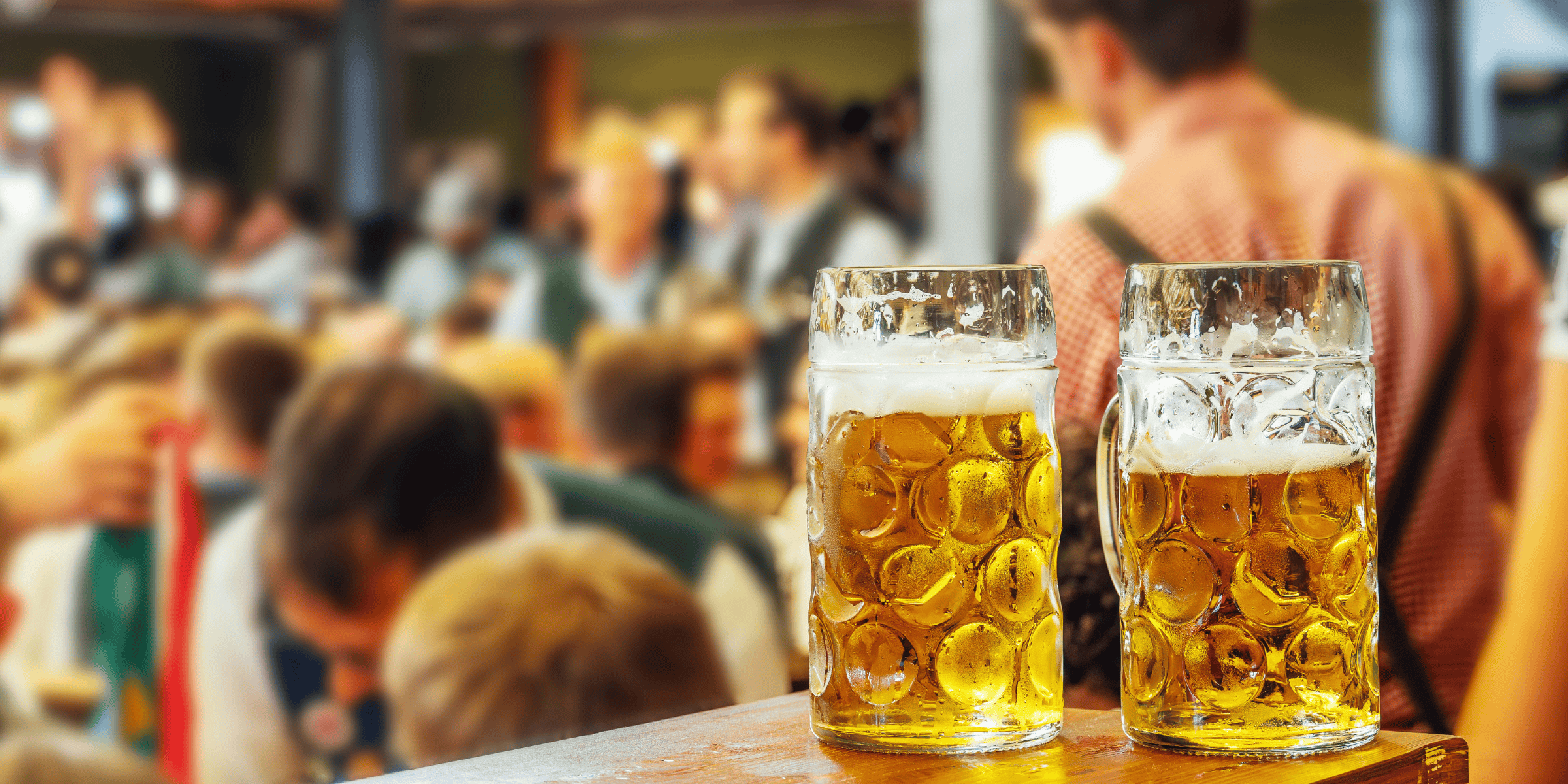 Zwei frisch gezapfte Biergläser vor einer geselligen Veranstaltung