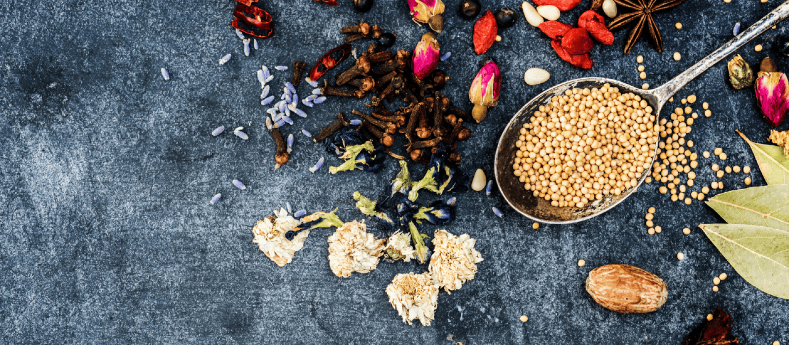 Aromatische Gewürze, Blüten und Senfkörner auf dunklem Hintergrund für natürliche Lebensmittel und Gewürzmischungen