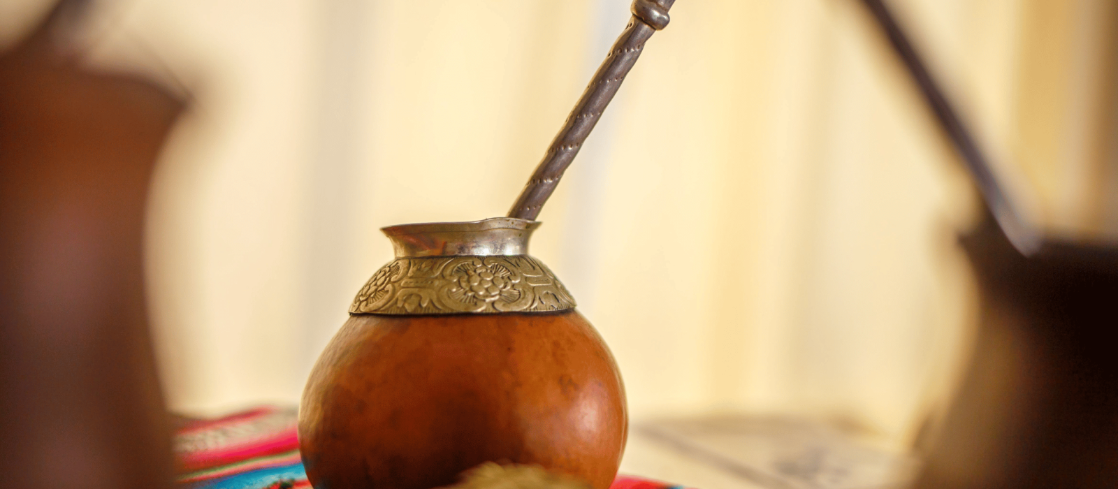 Mate Getränk im traditionellen Mate-Gefäß mit Bombilla auf einem bunten Tuch