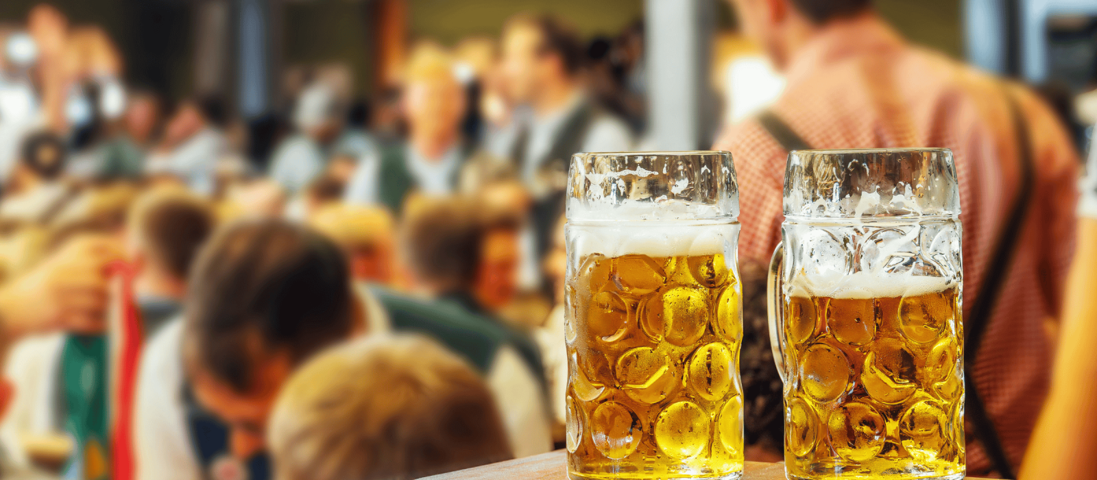 Zwei frisch gezapfte Biergläser vor einer geselligen Veranstaltung